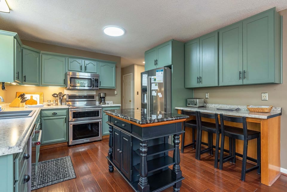 Updated kitchen with KitchenAid dishwasher, Crock Pot, Blender, Mixer, Drip-style coffeemaker, induction range with dual ovens, and bar seating for 3.