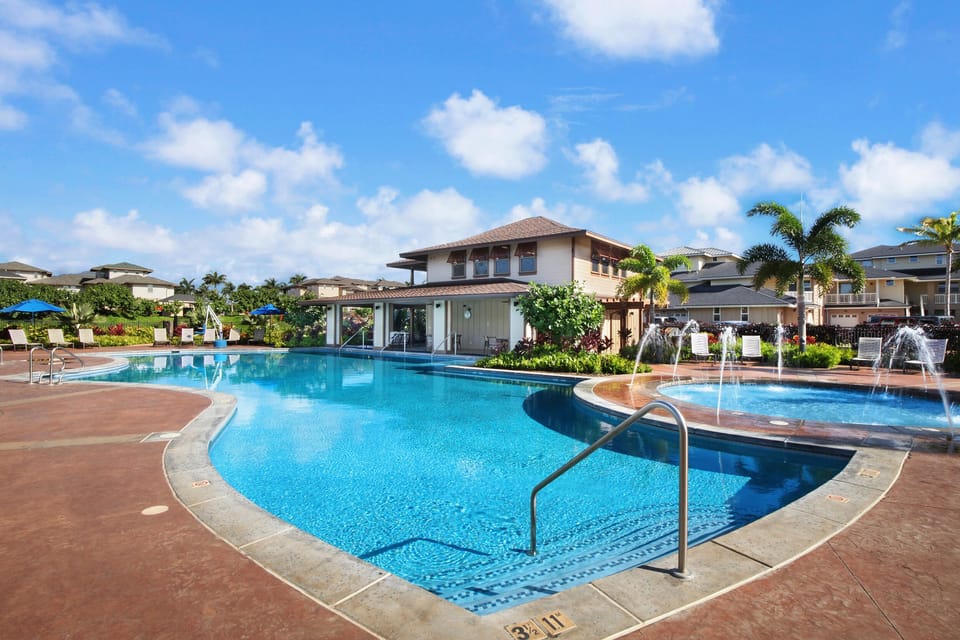 Resort-style pool at Pili Mai with sun loungers and tropical surroundings