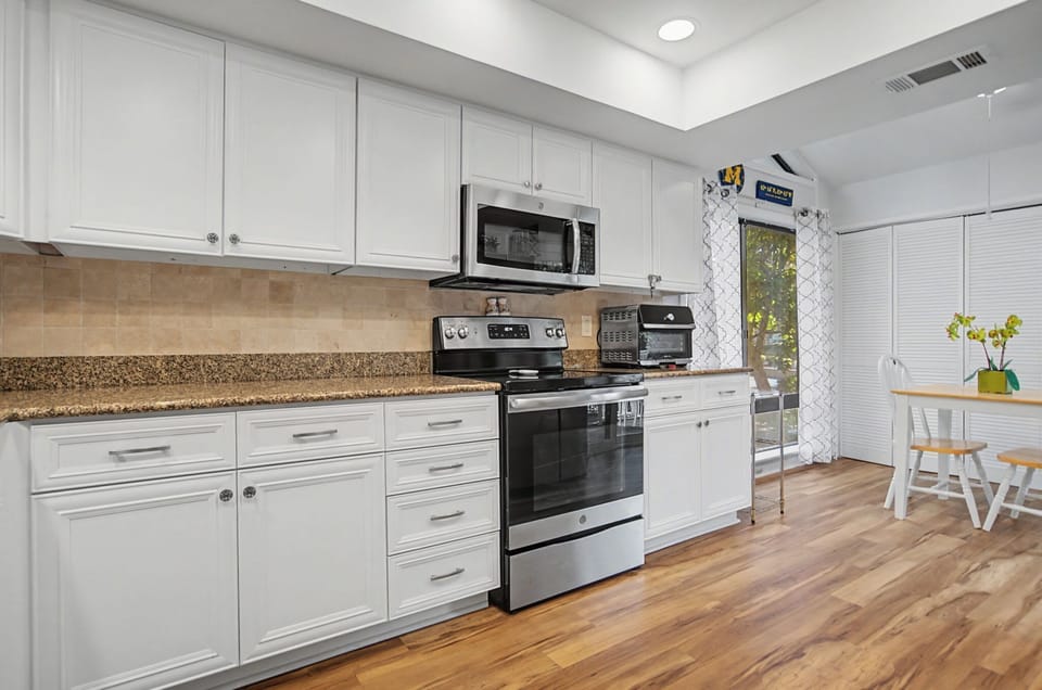 The kitchen includes a stove, oven, microwave, dishwasher, and fridge.