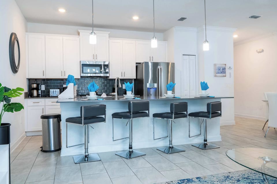 Bright open kitchen featuring stainless appliances and a long breakfast bar with seating for five-ideal for morning coffee and conversation.