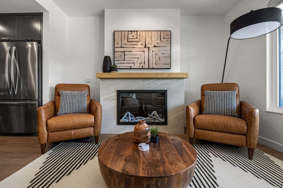 Main floor living room with an electric fireplace and recliners.