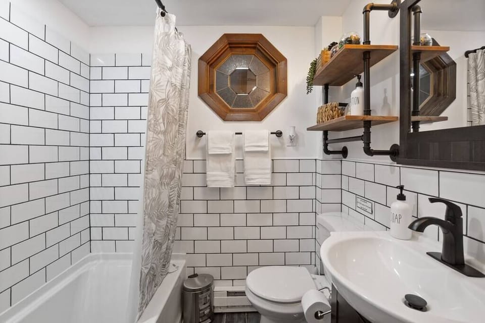 Full Bathroom View with Subway Tile
This bright bathroom features full subway tiling, a unique octagonal window, and a blend of rustic and modern fixtures that feel both fresh and timeless.
