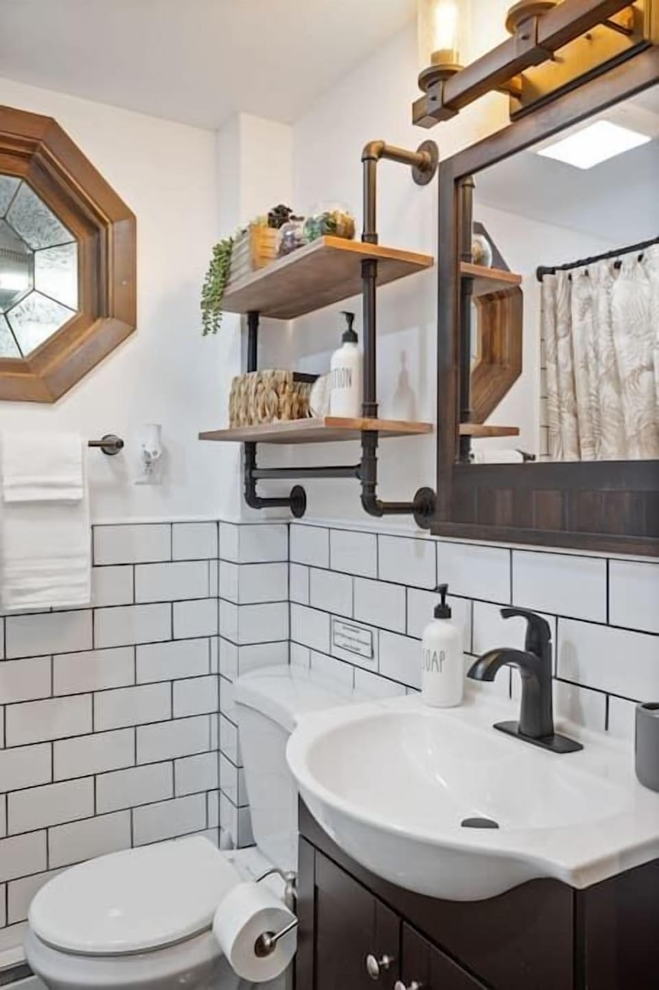 Sink and Mirror Detail with Open Shelving
Open pipe shelving adds a rustic-industrial charm, paired with matte black hardware and warm wood textures for a cozy, polished finish.