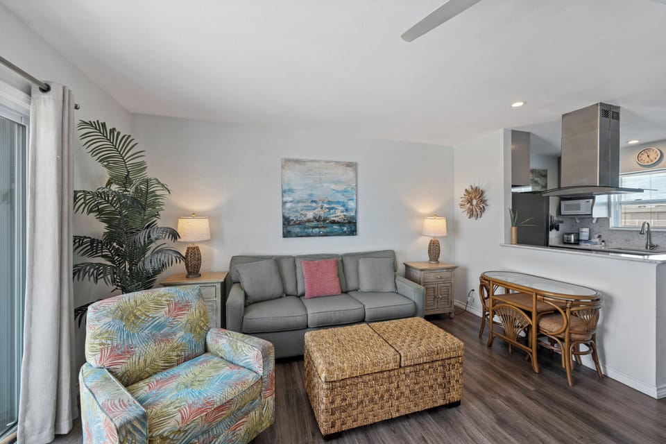 Sink into your comfortable living space where tropical touches and modern amenities create the perfect beach getaway atmosphere for relaxing evenings.