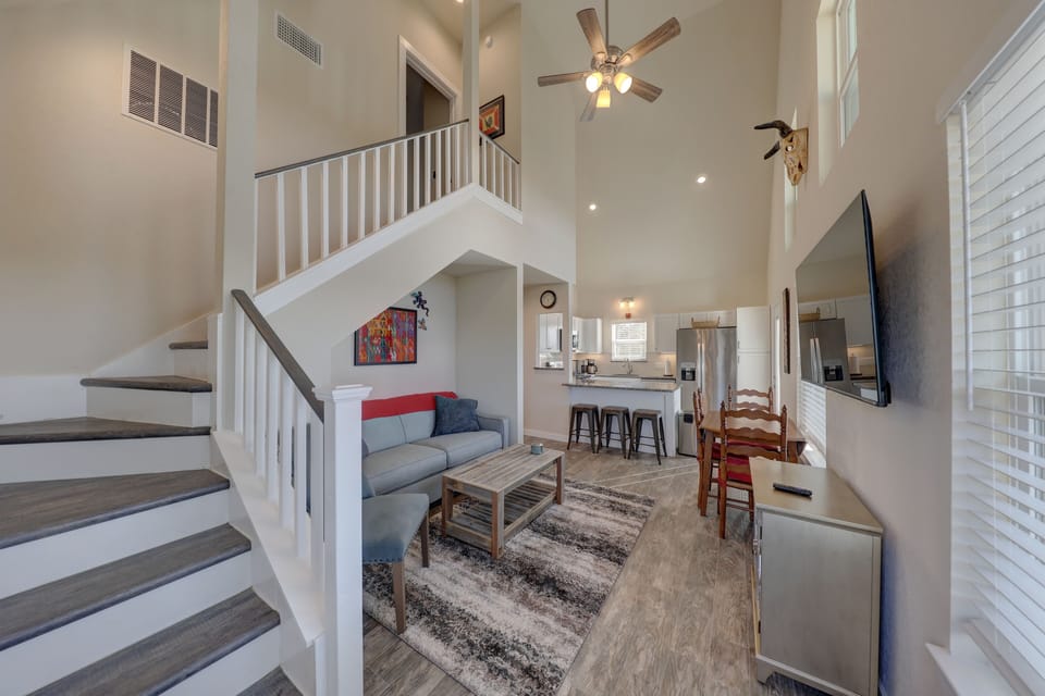 View of living area/Smart TV, ceiling fan & stairs to guest bed & 1/2 bath