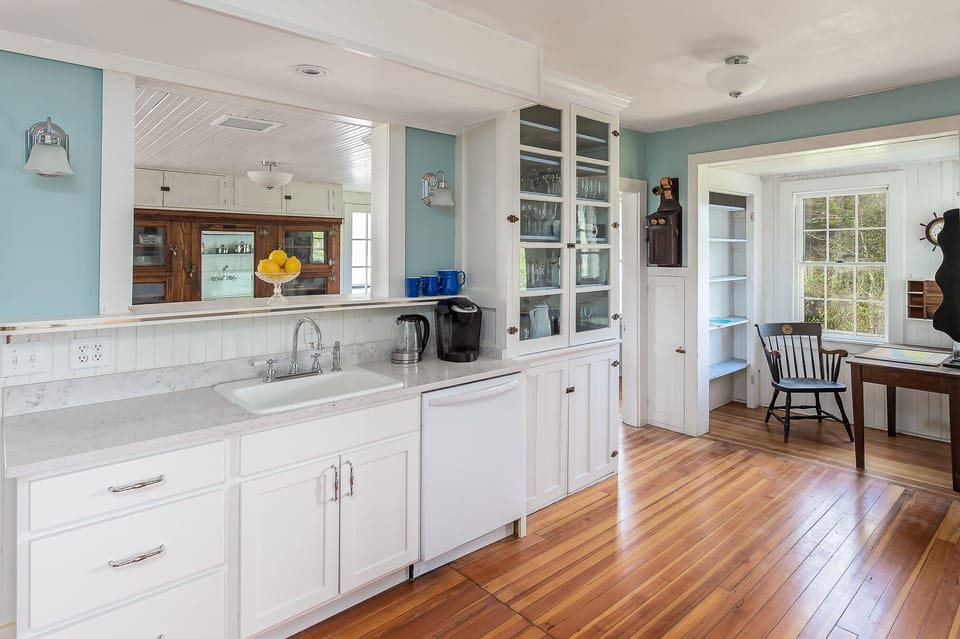 Spacious kitchen with pass-through, glass-front cabinets, & dedicated work space