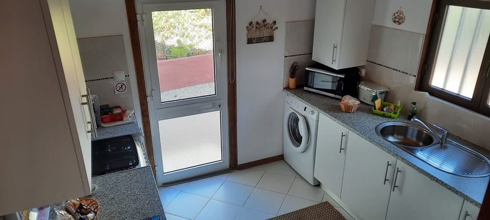 small well equipt  kitchen with washing machine.