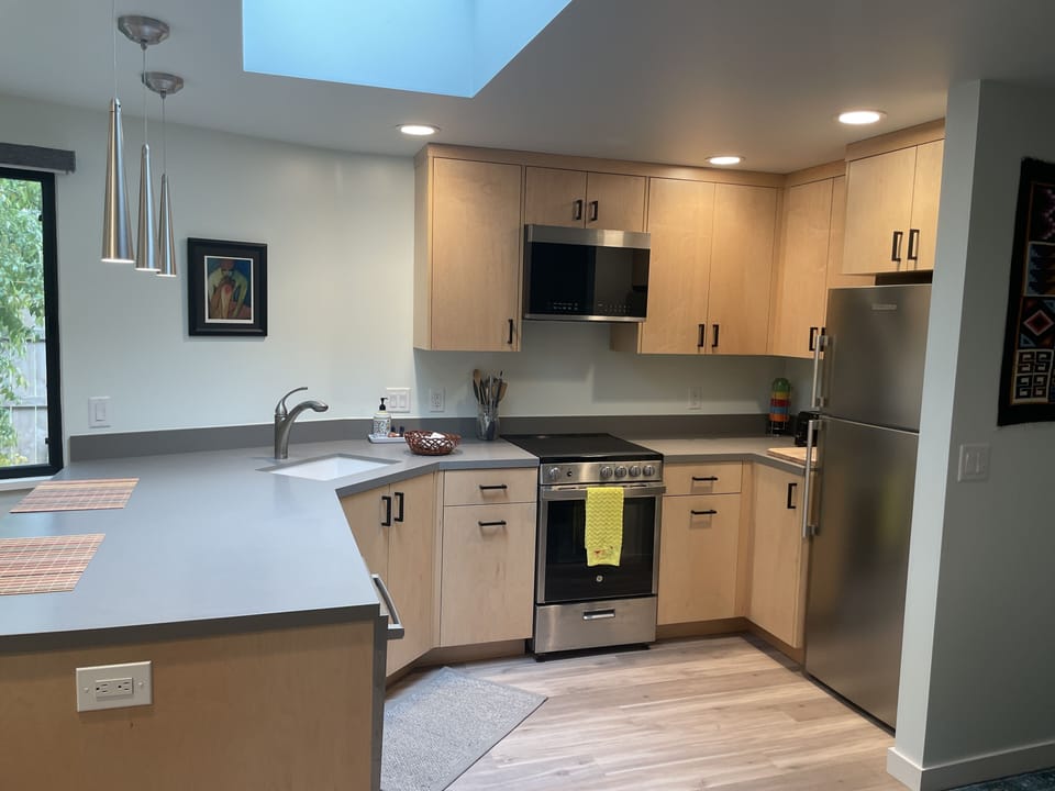 Full kitchen with fridge, range, apartment sized dishwasher, and microwave.