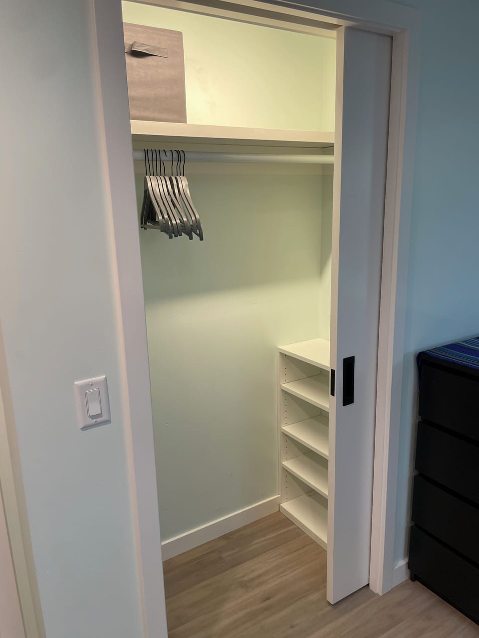 Closet with shelves and a full sized dresser give plenty of room for clothing.