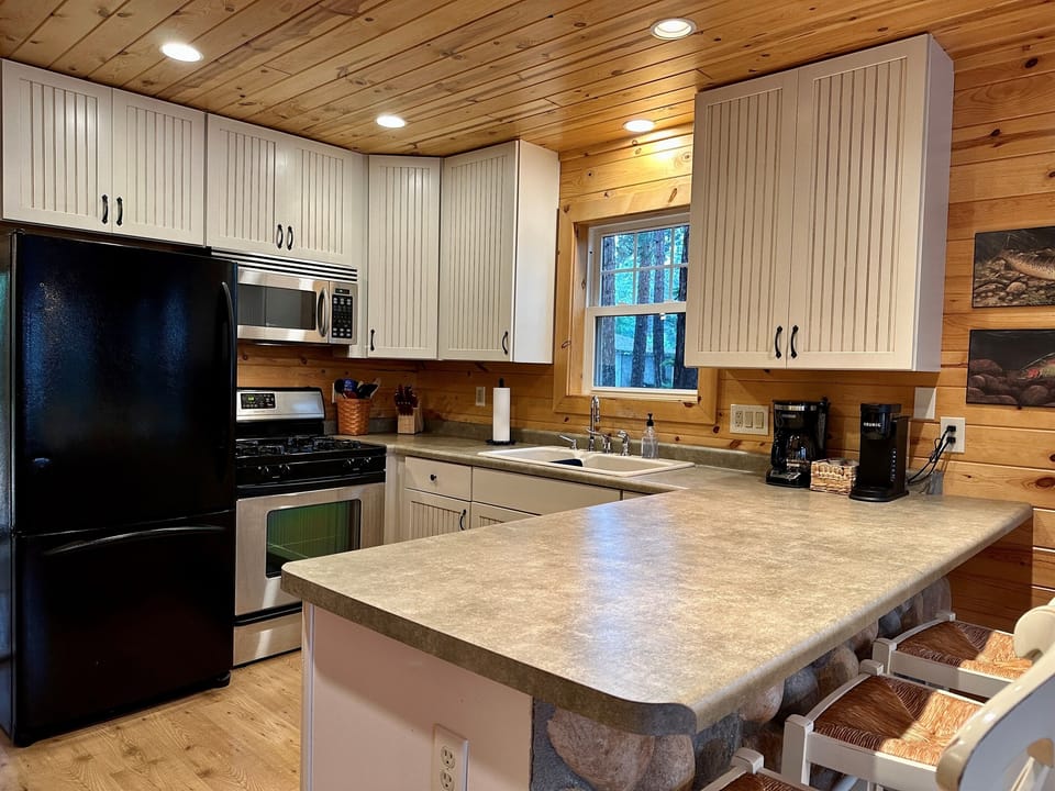 A warm and welcoming cabin kitchen with everything you need for weekend breakfasts, family dinners, morning coffee, and gathering together.