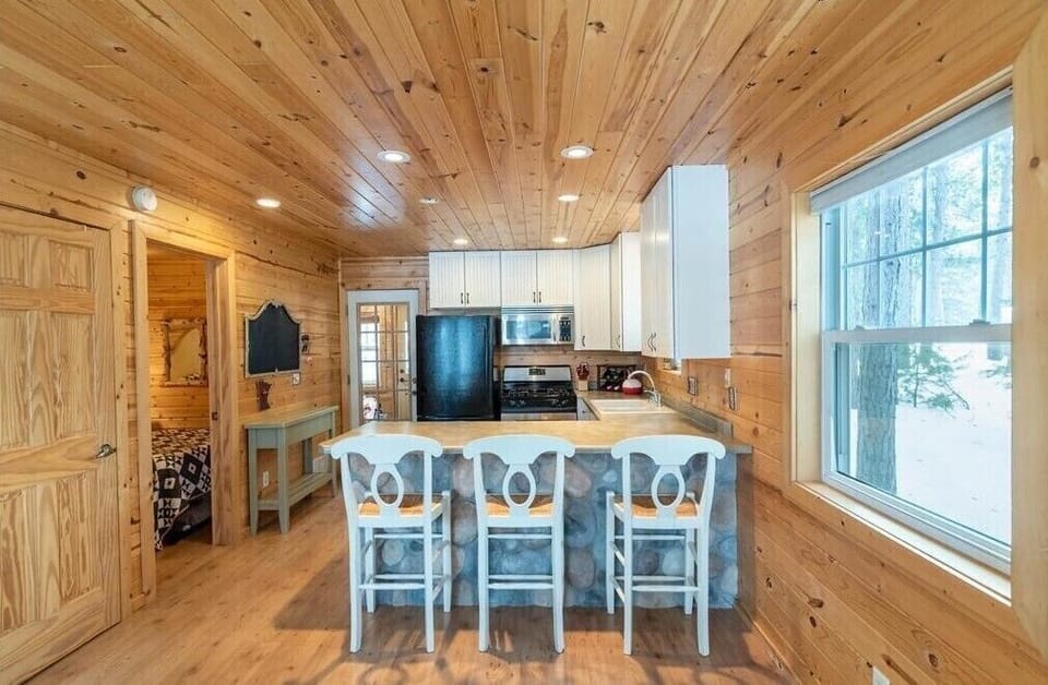 A fully equipped kitchen with breakfast bar seating, ideal for cozy meals and casual conversations.