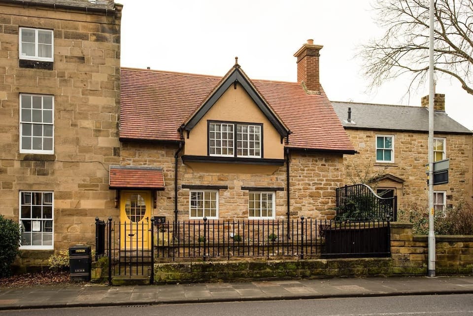 The Craftsman's Cottage - exterior view of property with its vibrant yellow front door