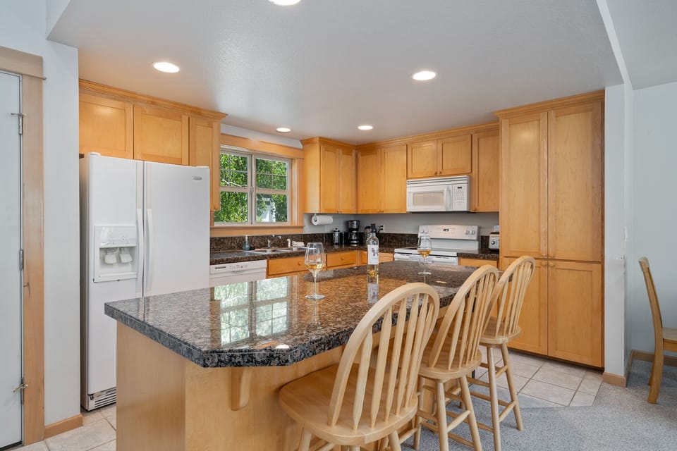 Kitchen - Fully equipped kitchen with breakfast bar, open to dining and living area with gas fireplace