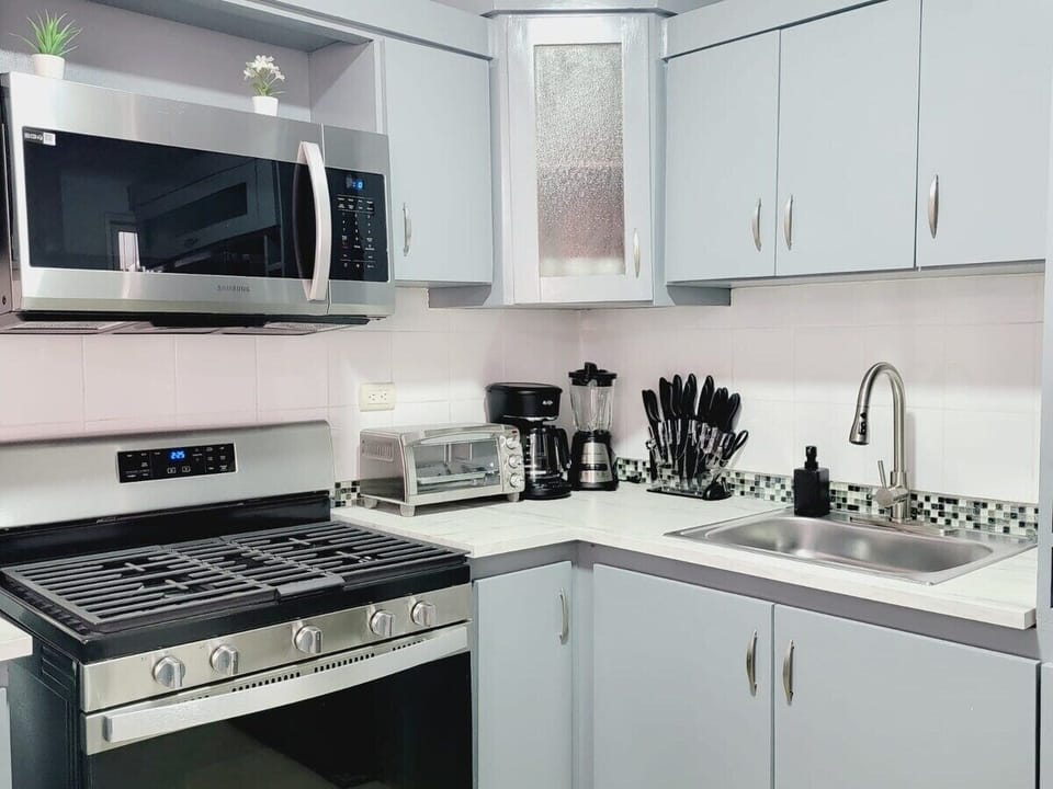 Experience culinary convenience in the fully equipped kitchen. From the over-the-stove microwave oven to the four-burner stove, toaster oven, and knife set, this kitchen is ready to fulfill all your cooking needs with efficiency and style. 
