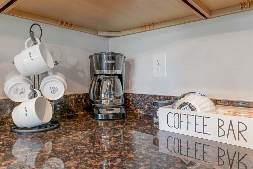 Start your mornings right at the dedicated coffee station, complete with a drip coffee maker and a decorative "Coffee Bar" organizer.