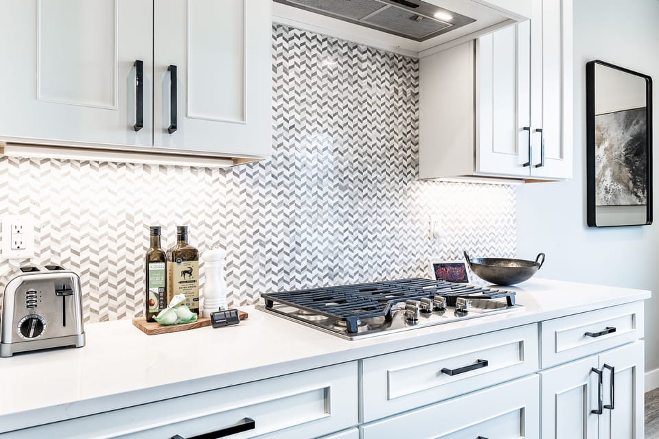 Beautiful Tile work above a professional style gas range cooktop