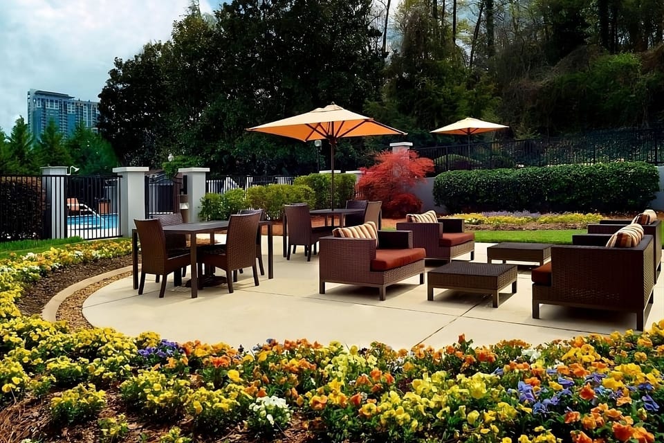 Gather outdoors among vibrant gardens and shaded lounge seating.