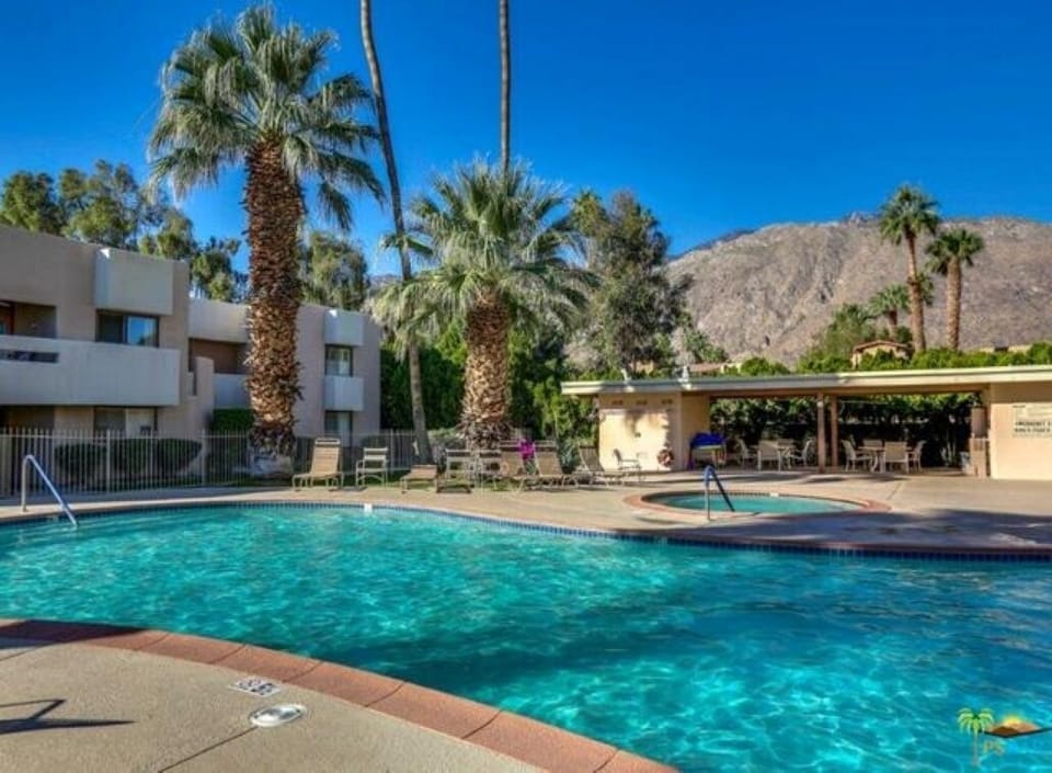Sparkling pool heated year round with hot tub in the distance.  