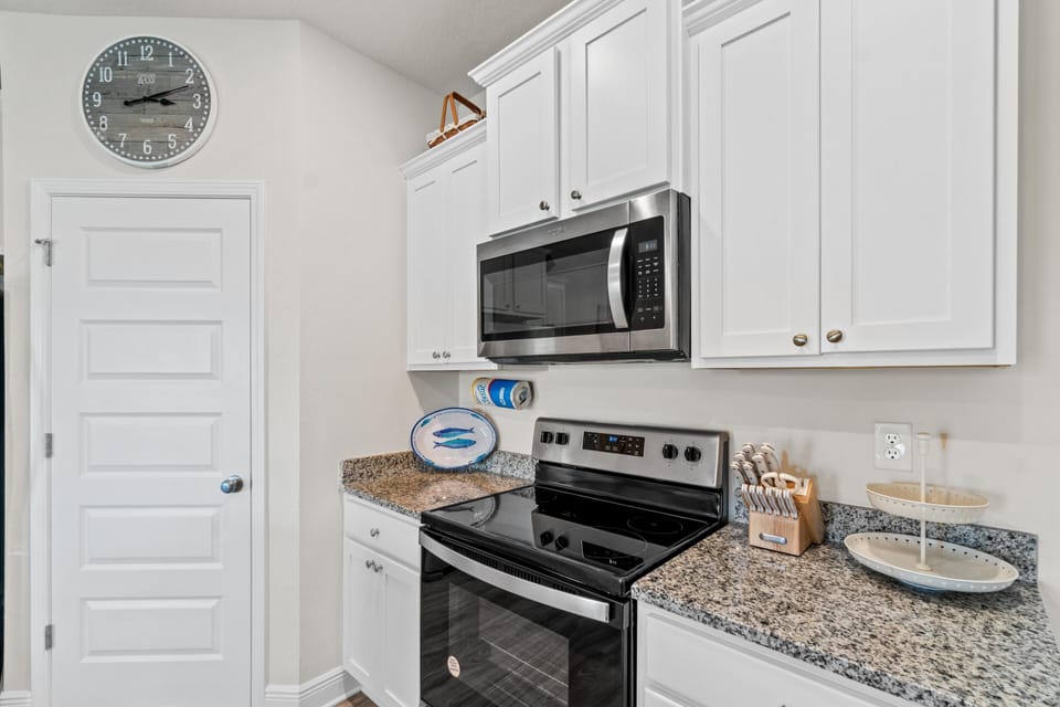 Whip up your favorite meals in this bright, fully-equipped kitchen featuring granite countertops, stainless steel appliances, and all the essentials for your stay.