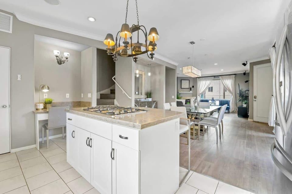 Bright and airy open-concept layout with a central kitchen island, cozy workspace, and seamless flow into the dining and living areas—perfect for entertaining, cooking, and staying connected with your group.
