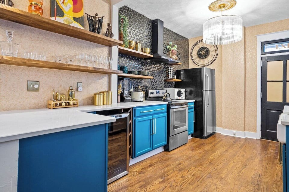 This lower level designer kitchen offers everything you need: stainless steel appliances, a wine fridge, open shelving, and luxe gold accents—all just minutes from KC’s streetcar and top dining spots.