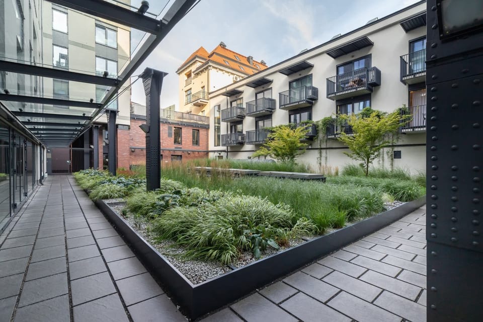 A beautifully landscaped courtyard surrounded by modern architecture, creating a peaceful outdoor retreat.
