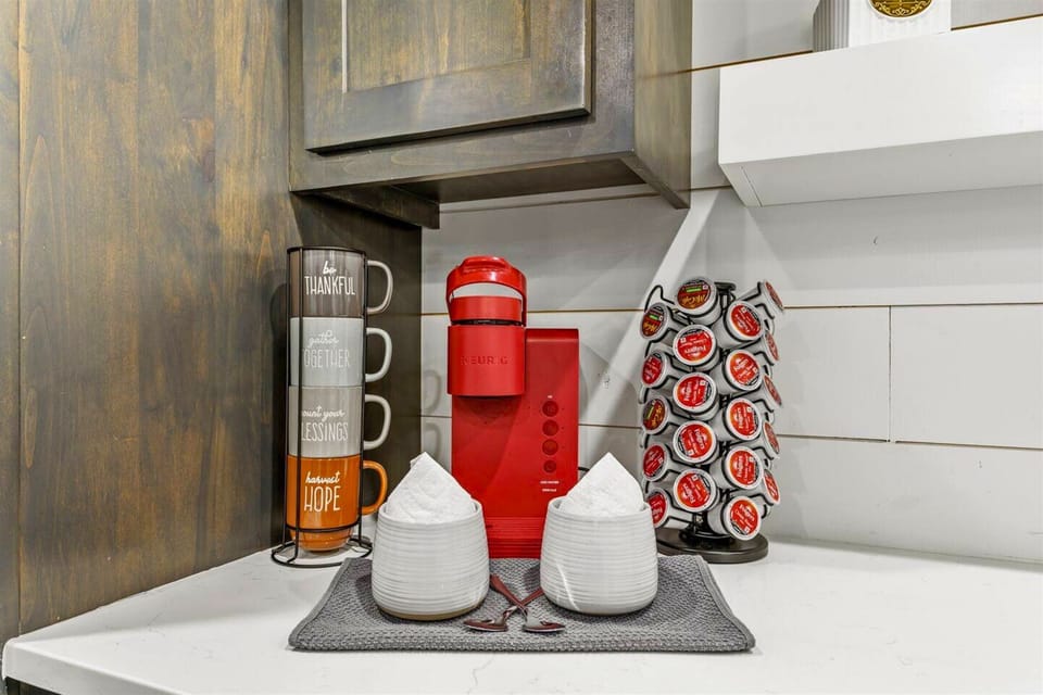 Start your day in our cozy coffee nook featuring a stylish red Keurig and a variety of coffee choices.