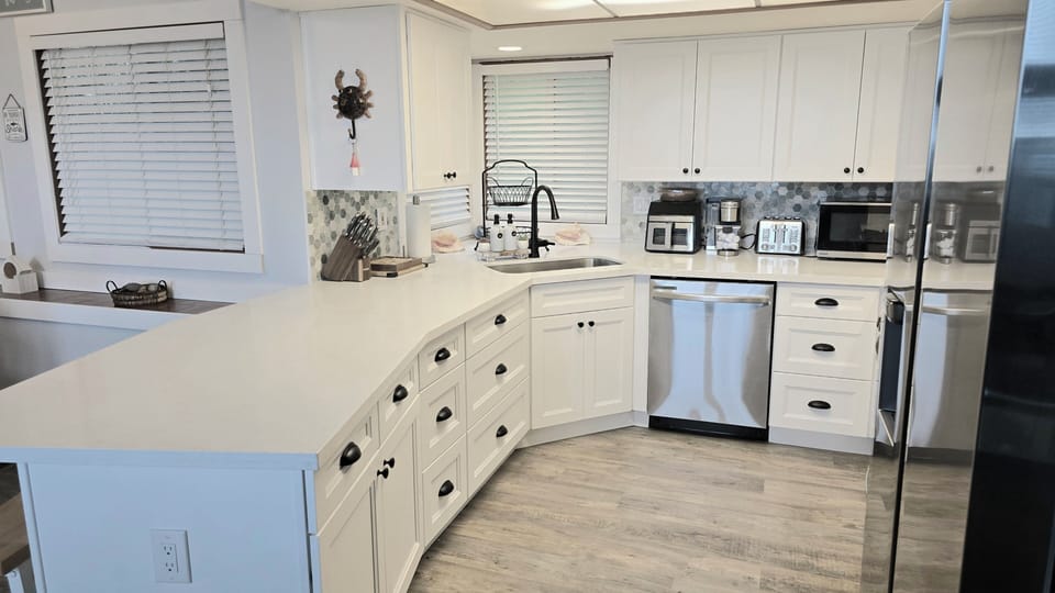 Large kitchen sink with deep counters and gas stove. Many appliances for use.