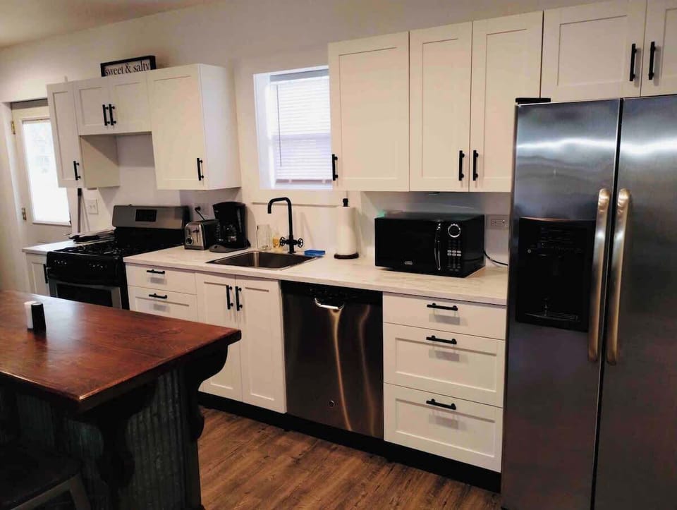 (KITCHEN) Step inside to a polished, modern kitchen outfitted with polished stainless steel appliances. Cook with ease, and enjoy the added convenience of a dishwasher and a fridge with filtered water—perfect for everyday meals or extended stays.