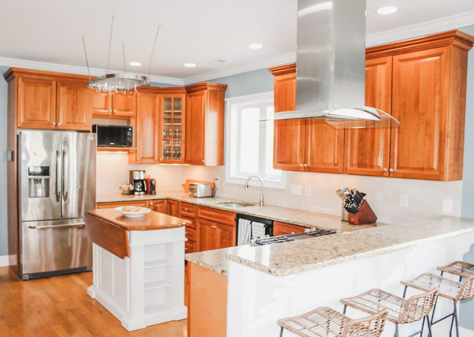 Fully stocked kitchen with stainless steel appliances and breakfast counter 