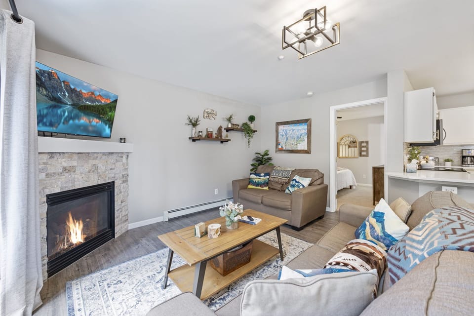 Living room area with ample seating, sleeper sofa, gas fireplace, large Roku tv
