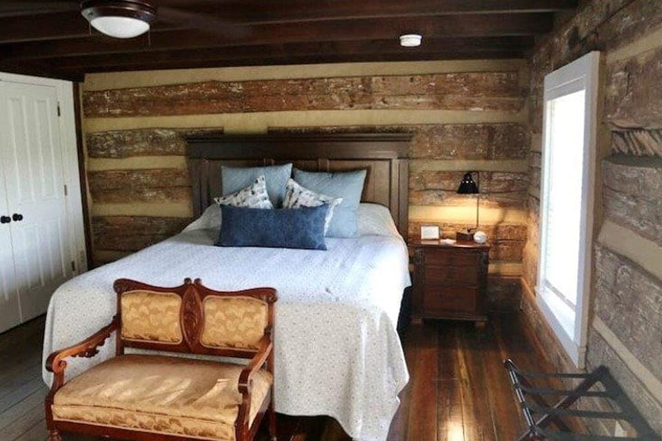 King bedroom with original exposed logs dating back to 1780.