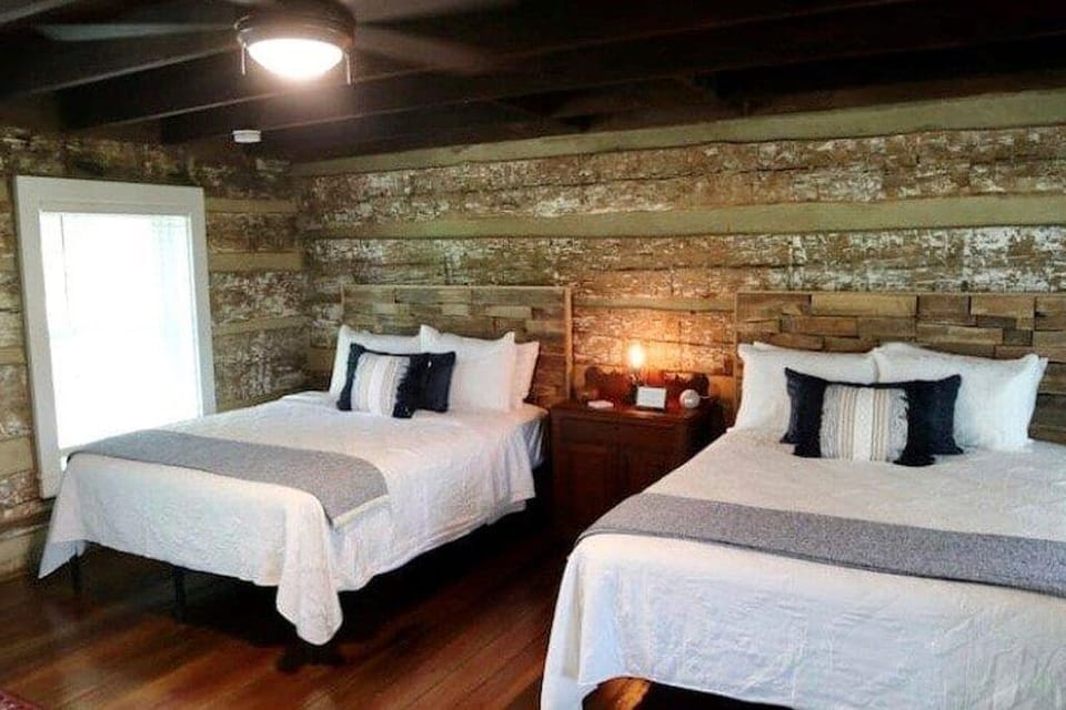 Double queen bedroom with original exposed logs.