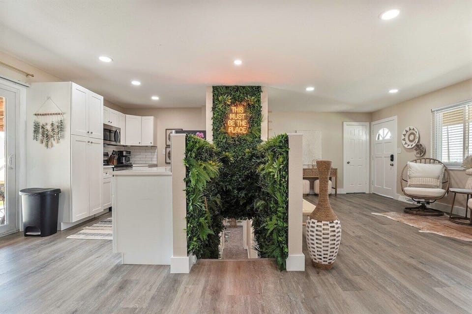 Assymetrical view of the kitchen and foyer separated by this jungle-like space
