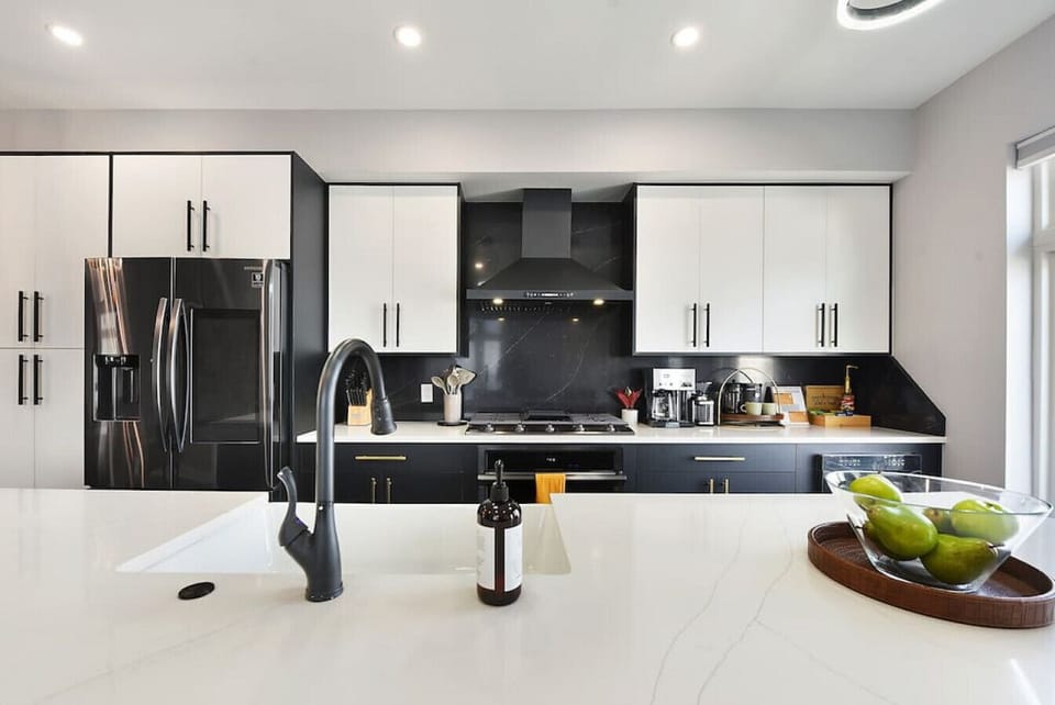 Fully equipped modern kitchen with stainless steel appliances, quartz countertops, and spacious island seating