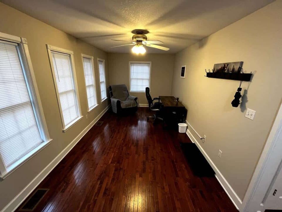 Sunlit Office Retreat: Bright space with classic hardwood, a desk to inspire creativity, and a relaxing chair!