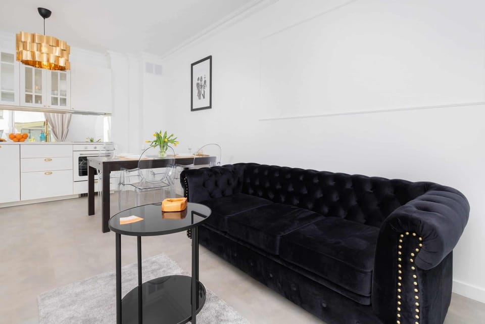 A close-up of the elegant black tufted sofa with metallic accents, adding a touch of sophistication to the living room.
