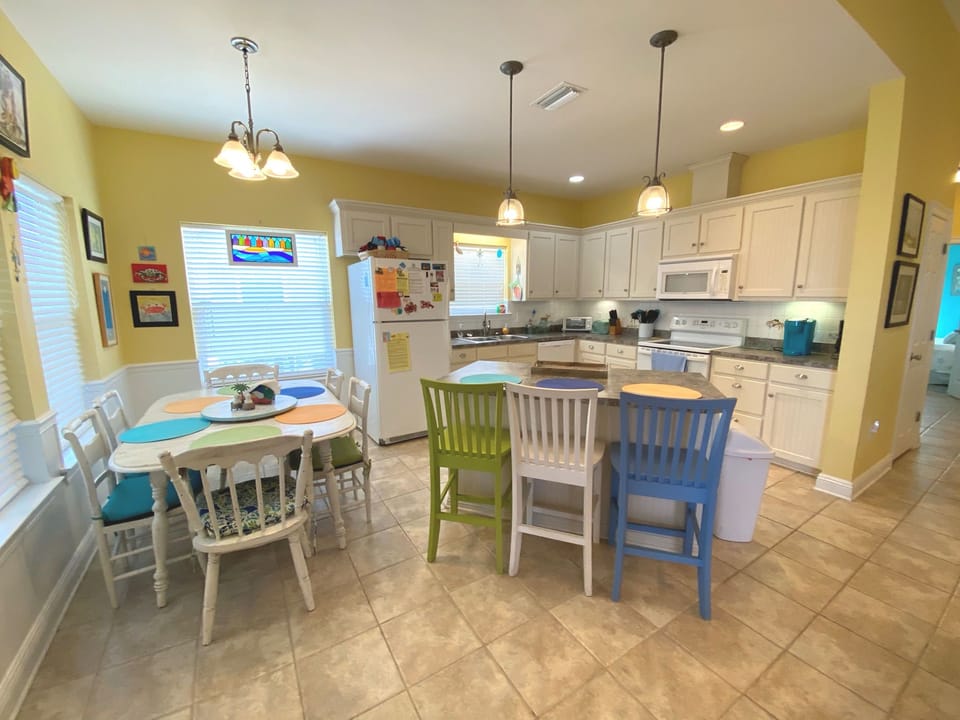 Gather around the cheerful dining area and fully-equipped kitchen where your family memories begin with colorful seating and endless meal possibilities.
