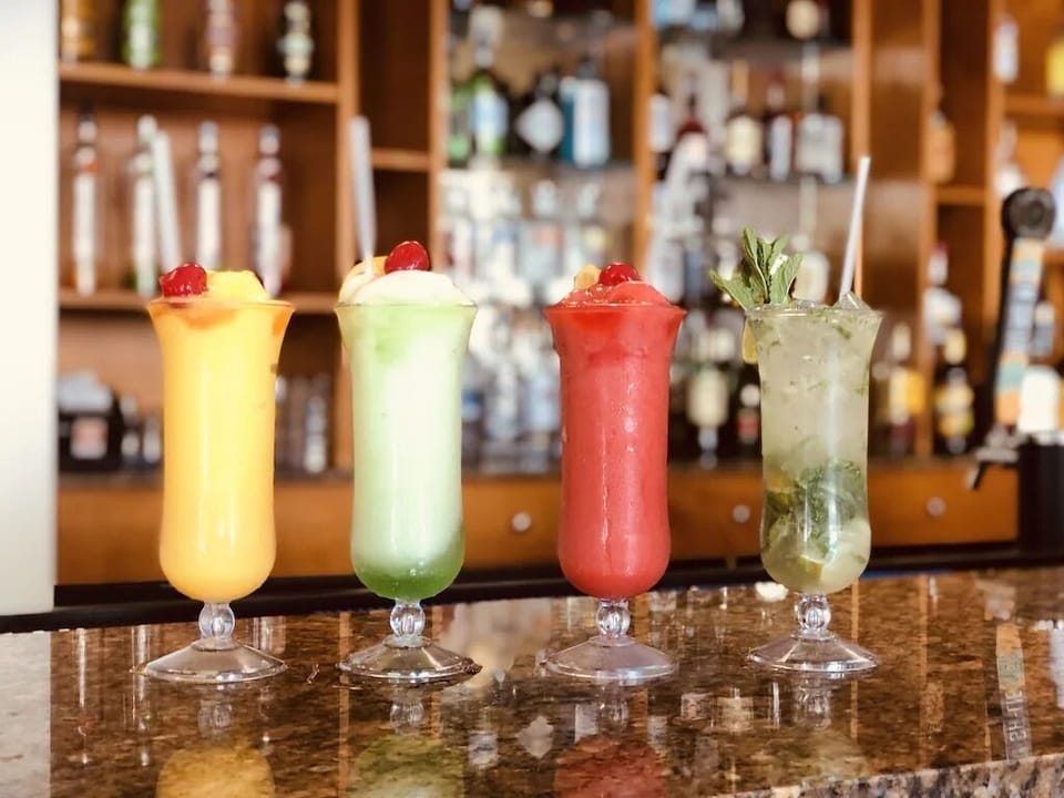 Enjoy drinks at our full service bar with full food menu/pool & beach service