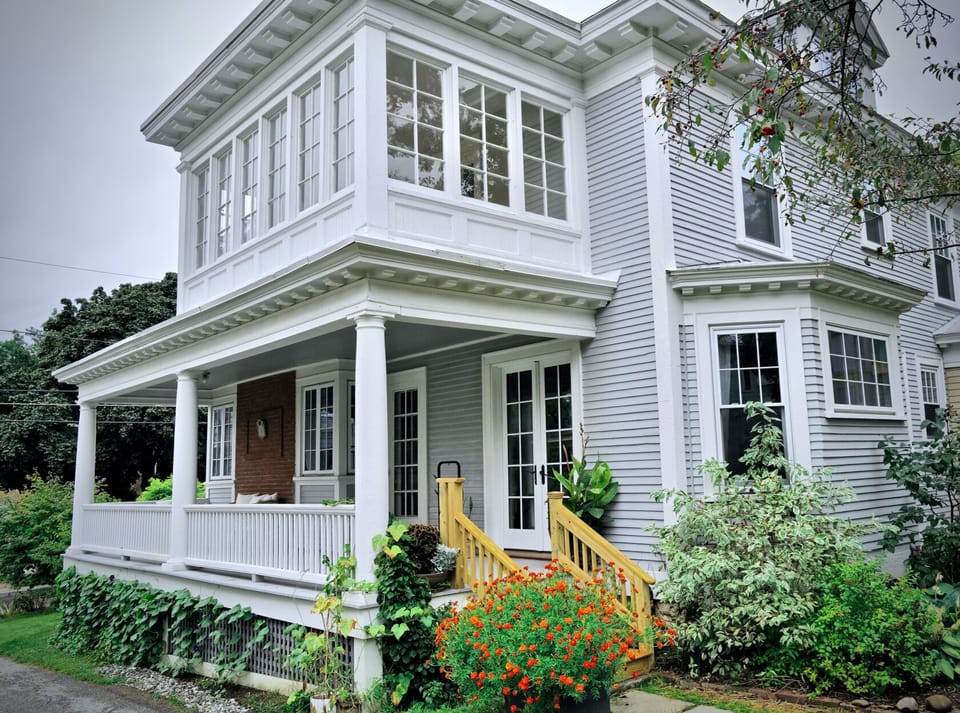 View of the side porch & sunroom above with wonderful architectural details.
