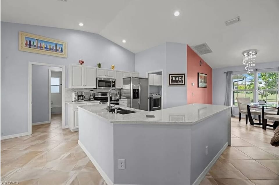 Kitchen with Cabinets, Leading to Washer and Dryer Room with more Cabinetry
