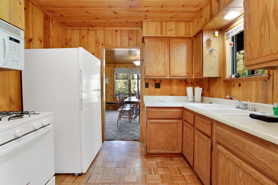 Fully equipped cabin kitchen with ample cabinetry, stove, fridge, microwave, and coffee maker—perfect for cooking meals, morning coffee, and feeling right at home on your stay.