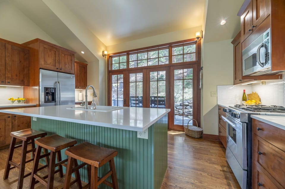 Quartz countertops and island seating with access to the outdoor deck 