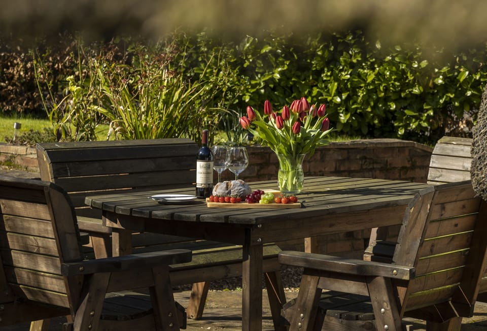 Paved terrace with garden furniture for alfresco dining at Corner Thatch