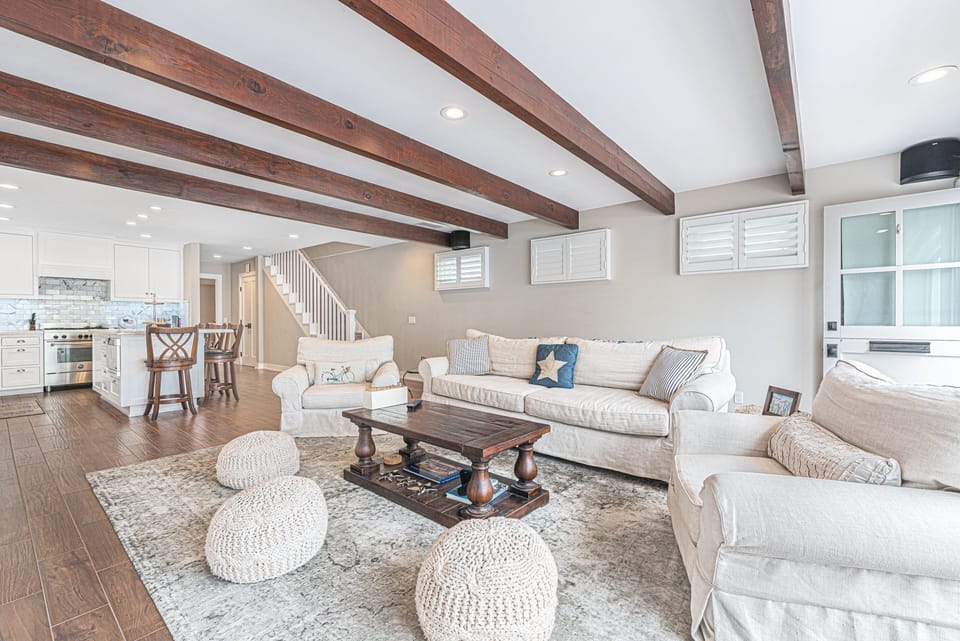 The downstairs living area comes with a large sofa and additional seating, TV. accordion sliding doors open out to large front (lower) patio.
                