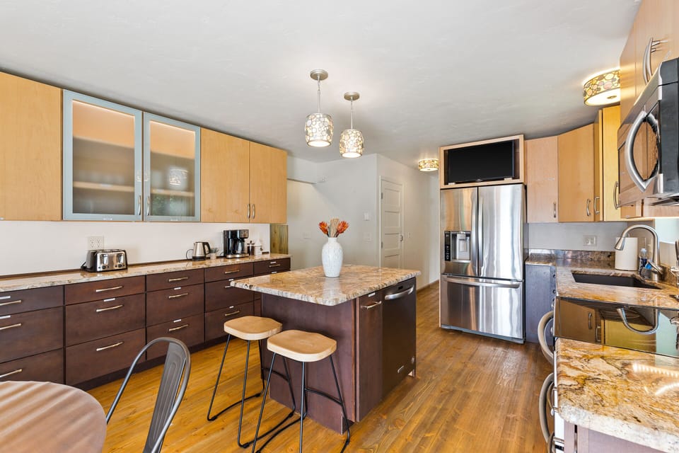 View of spacious modern kitchen, island & breakfast bar