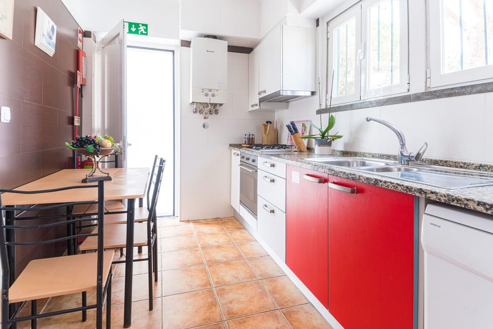 Modern kitchen with red cabinetry and granite countertops — Villa Cassandra, luxury holiday villa in Sintra