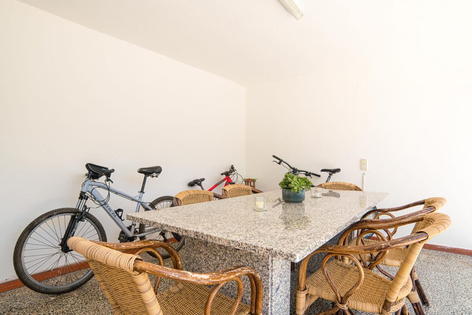 Outdoor dining area with bicycles and wicker chairs — Villa Cassandra, holiday villa in Sintra