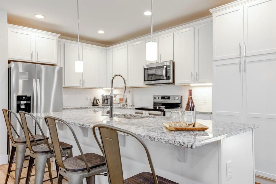 Our kitchen boasts a large island for entertaining. Stainless steel appliances, and granite countertops.  