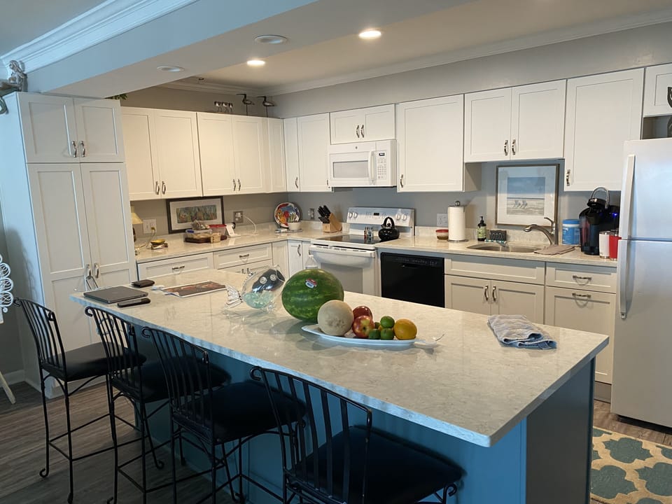 Kitchen with generous cabinet storage area & 4 bar stools.